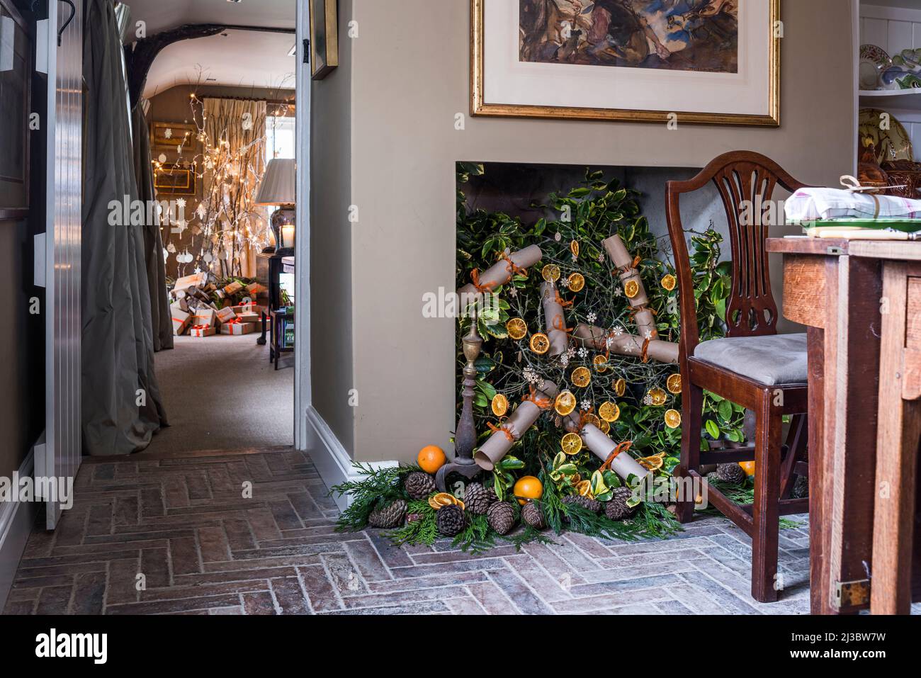 Christmas crackers and sliced orange display with brick flooring in 18th century Suffolk cottage at Christmas, UK Stock Photo