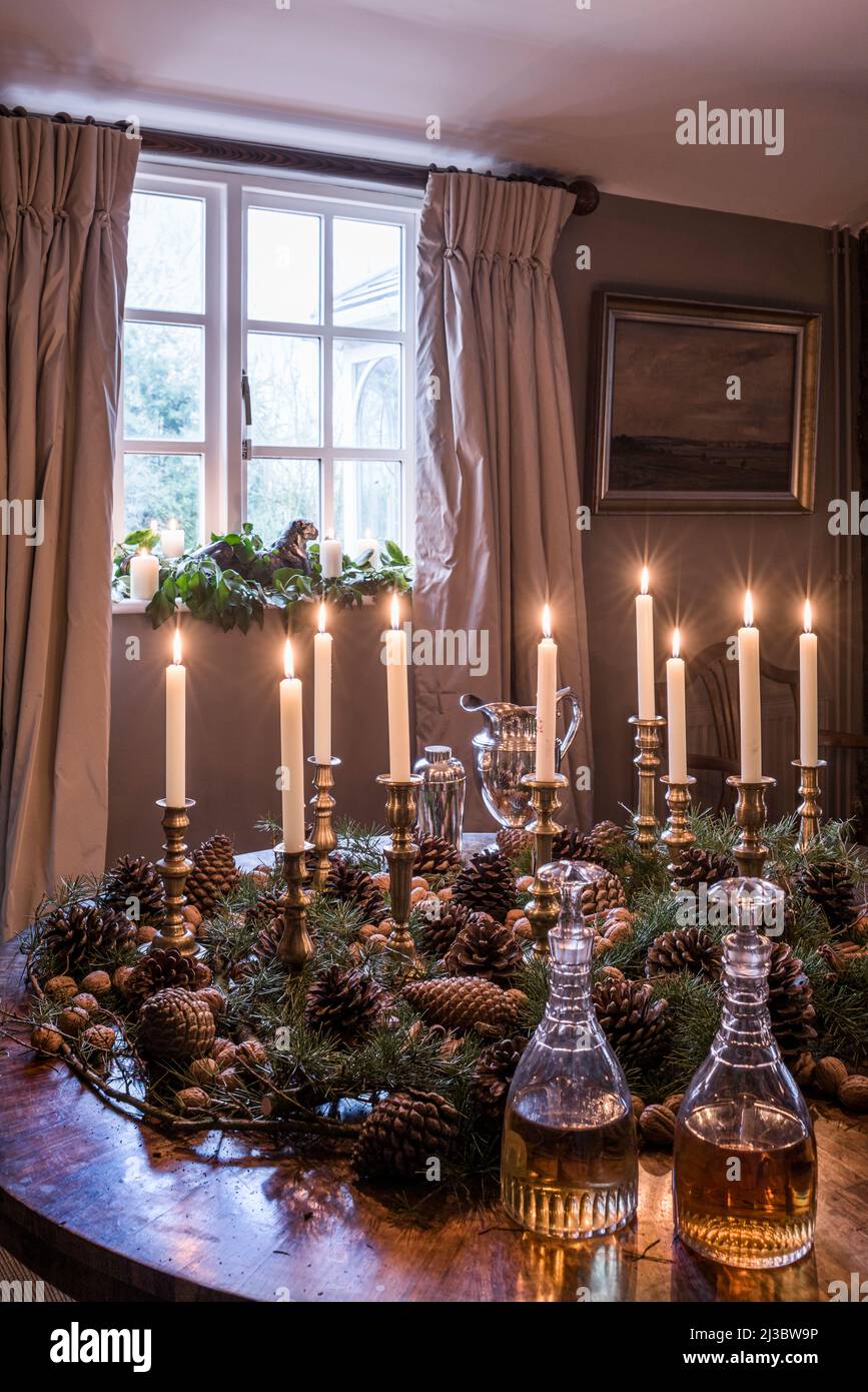 Lit candles and pinecones on table with decanters in 18th century