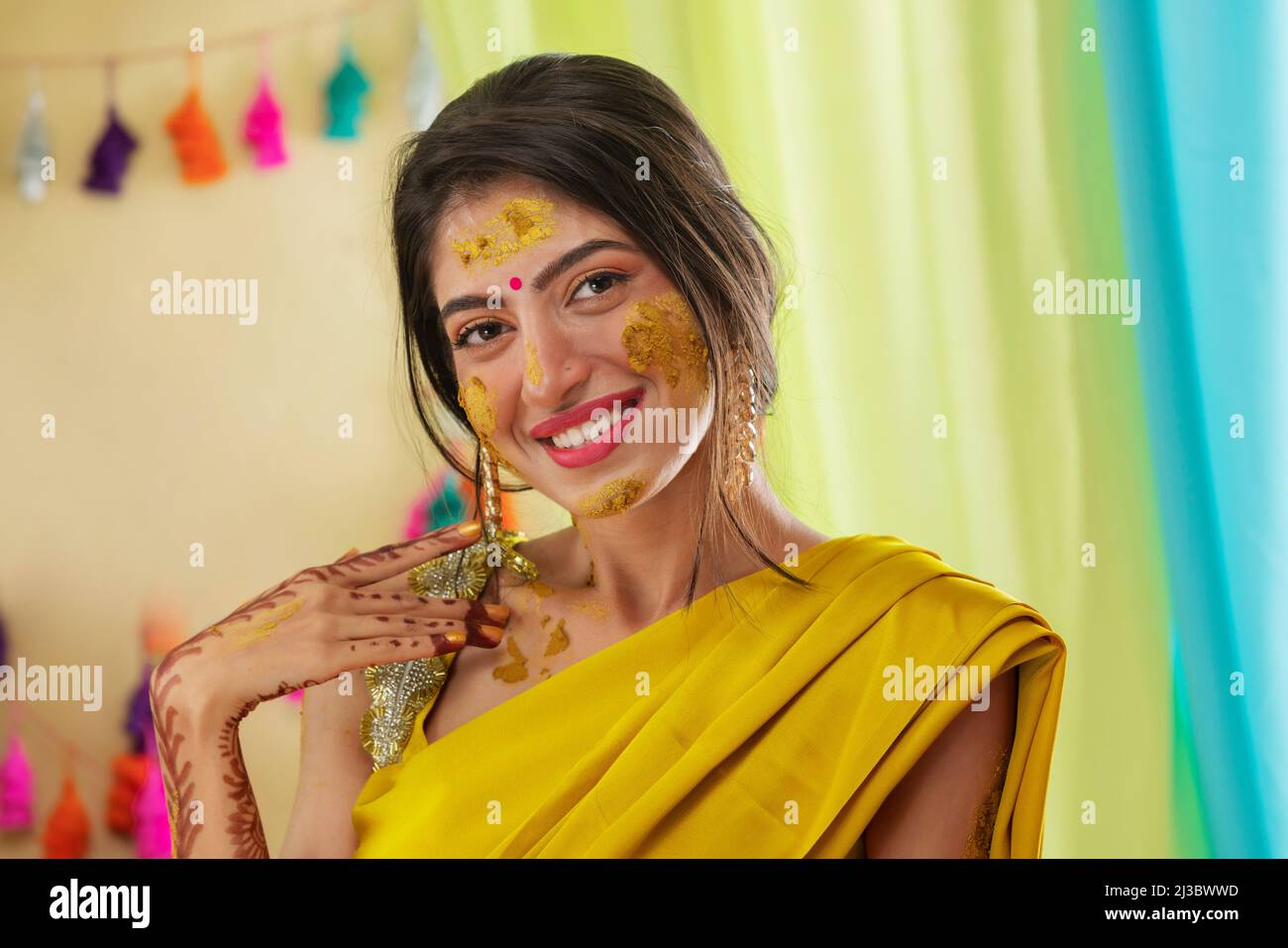 Close-up portrait of an Indian bride with turmeric applied on face Stock Photo