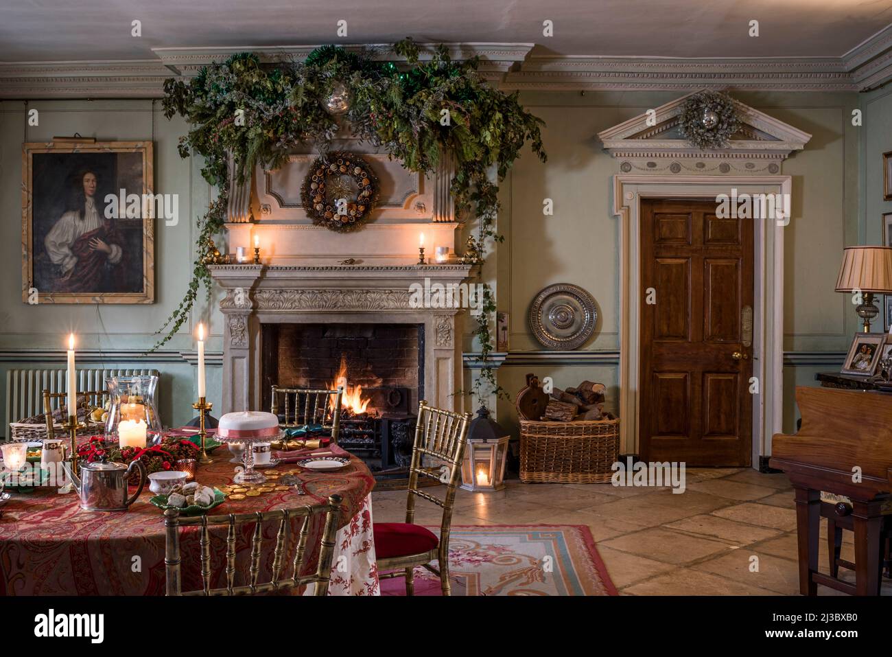 Canopy of foliage over carved stone fireplace in renovated Grade II listed mansion,  Cambridgeshire, England, UK Stock Photo