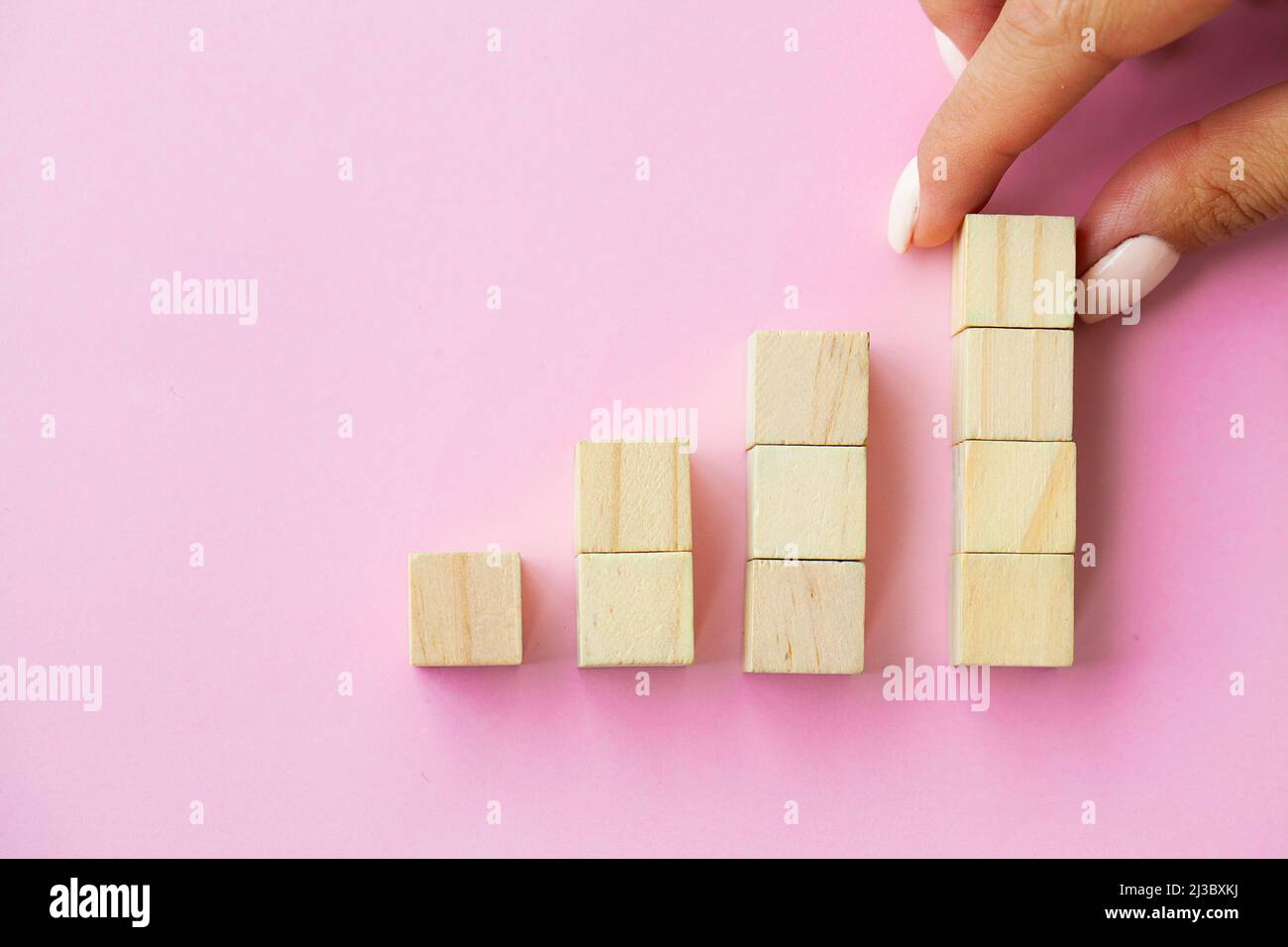 Hand arranging wood cube stacking as step stair Stock Photo - Alamy