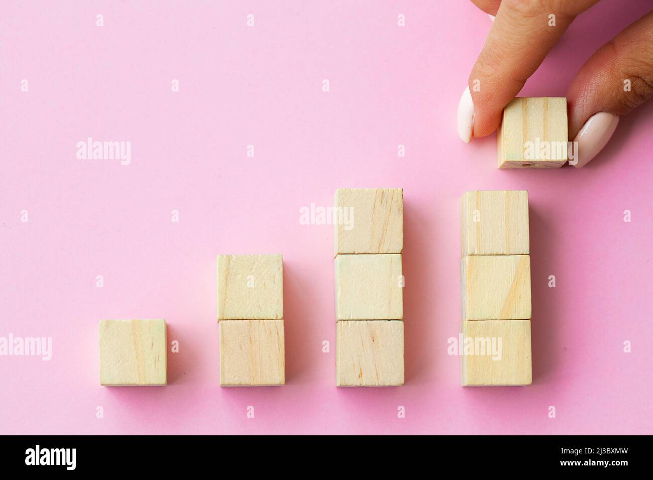 Hand arranging wood cube stacking as step stair Stock Photo - Alamy