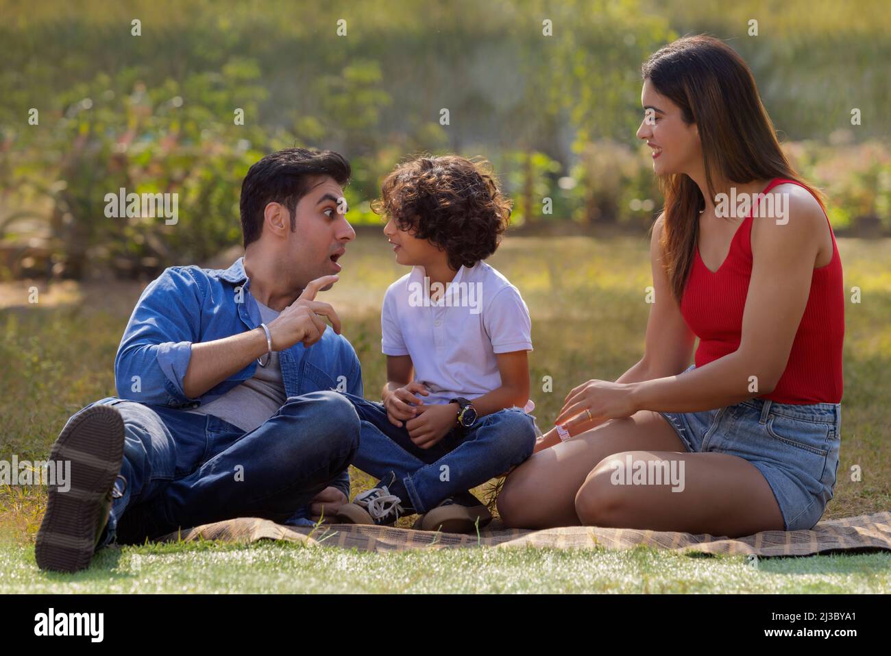 Happy couple with their son spending time in the park Stock Photo