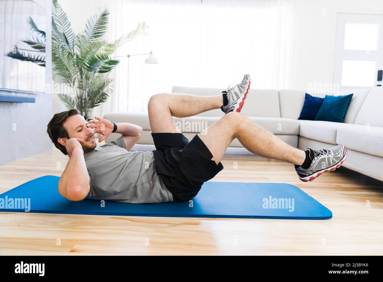 Attractive Fit man Exercise at home on the living room Stock Photo - Alamy