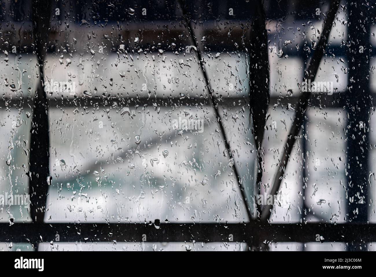 window pane covered with raindrops that are in focus Stock Photo