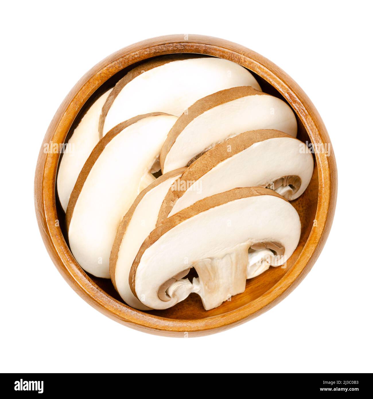 Brown champignons, sliced raw and young mushrooms in a wooden bowl. Agaricus bisporus, known as Swiss, Roman or Italian brown mushroom. Stock Photo