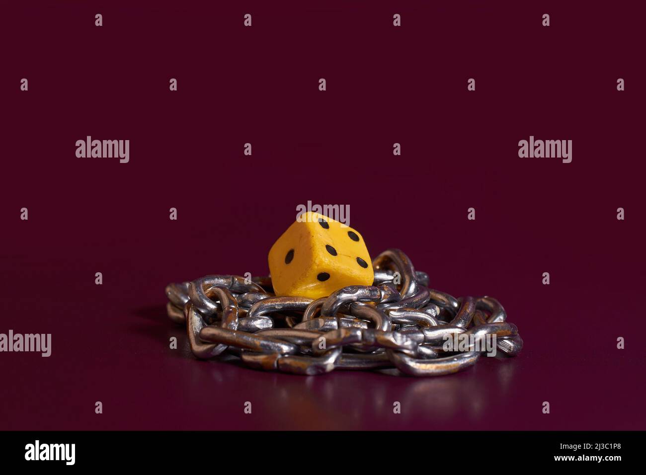 Gambling addiction. The game cube is wrapped with a chain  Stock Photo