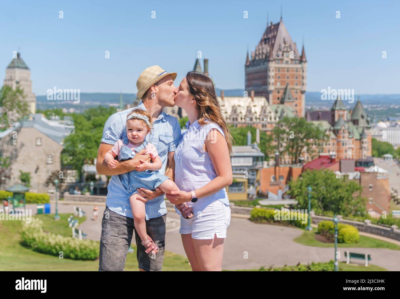 nice Couple with baby in front of Chateau Frontenac at Quebec city in summer season Stock Photo