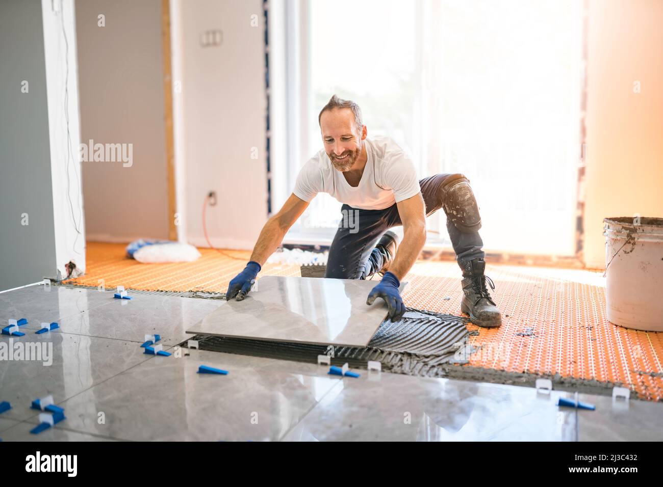 nice handyman install tile on the floor Stock Photo Alamy
