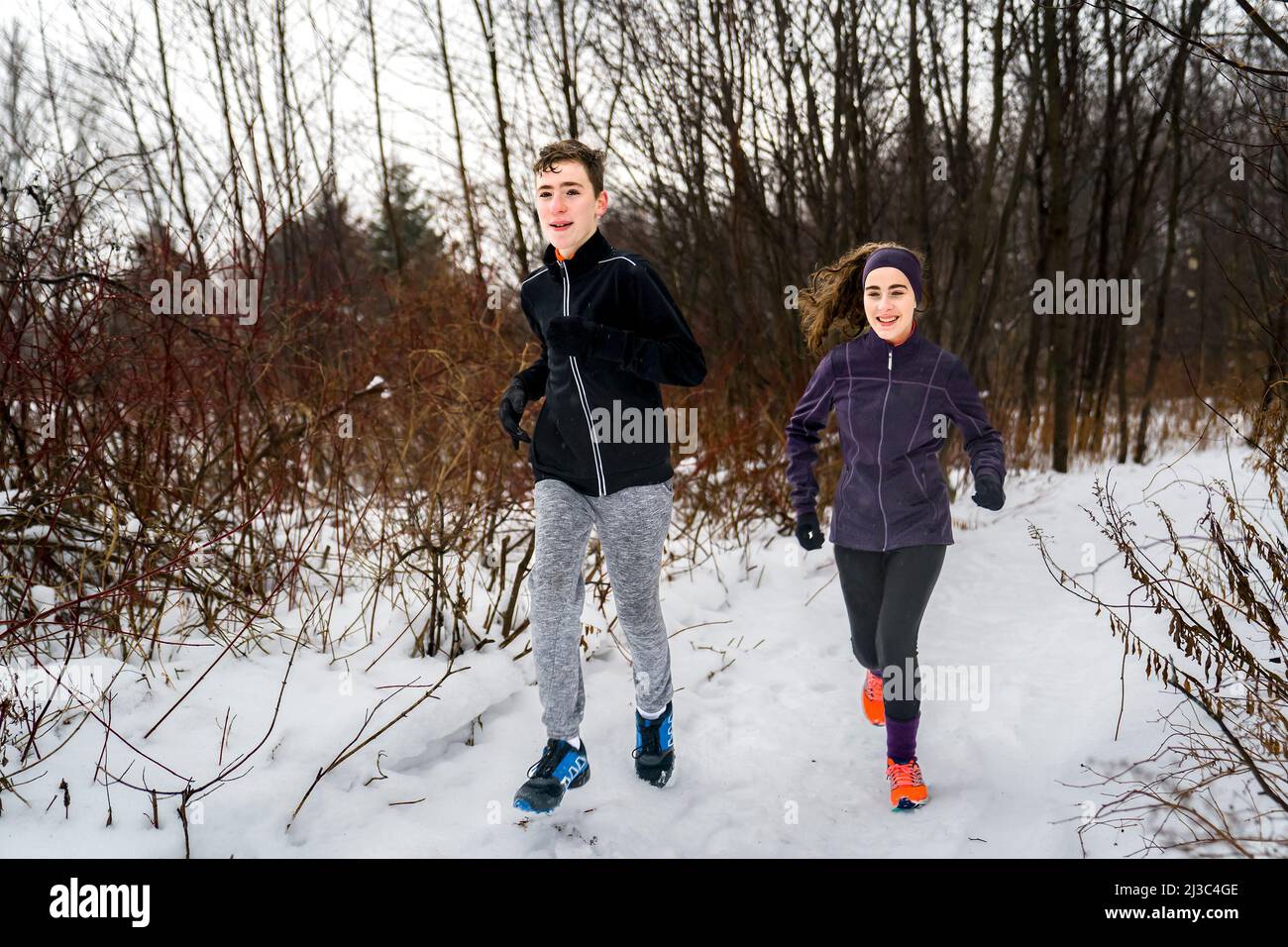 two twin brother and sister running in winter forest Stock Photo - Alamy