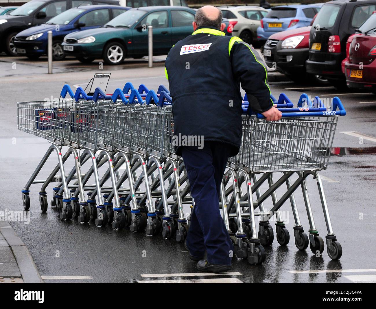 File photo dated 31/12/13 of a Tesco employee collecting trolleys at a Tesco store in Burton On Trent, as Tesco has said that its hourly pay for shop staff and warehouse workers will be increased by 5.8% from £9.55 to £10.10. Stock Photo