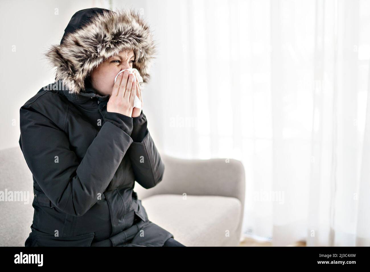 Woman With Warm Clothing Feeling The Cold Inside House on the sofa she