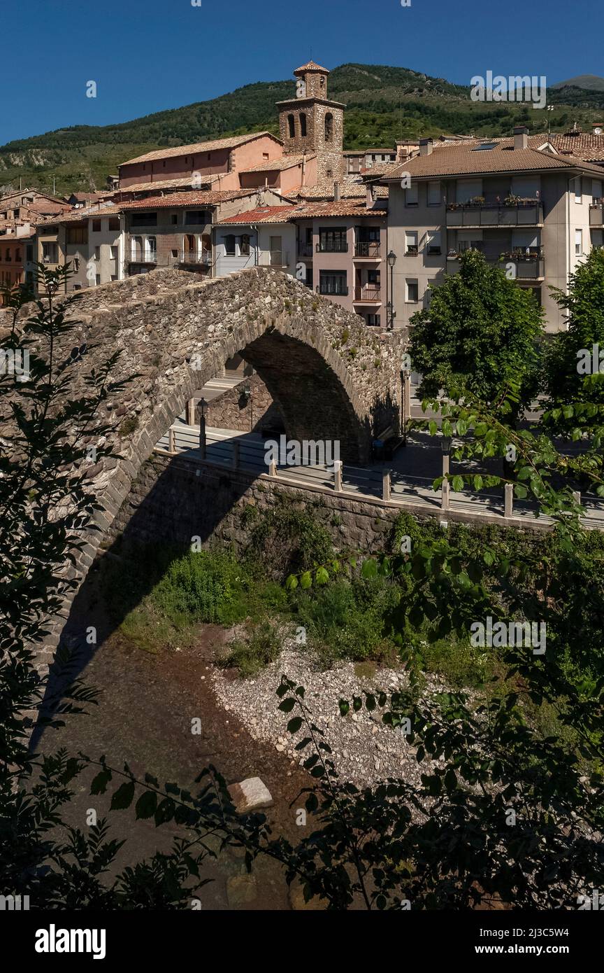 The medieval Pont Vell or Old Bridge, built in the 14th century, now spans the Llobregat river at La Pobla de Lillet in Catalonia, Spain, with a single, graceful donkey back arch, but it may once have had two arches and the ashlar foundations of the pillars suggest its origins may be Roman. Stock Photo