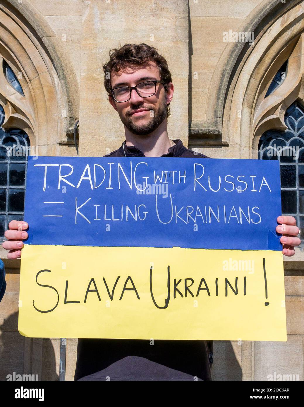 A protester outside Bath Abbey holds up an anti-war placard as he takes part in a demonstration against Russia's invasion of Ukraine Stock Photo