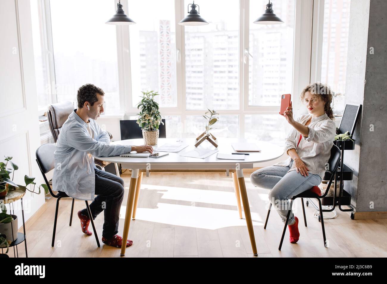 Stylish happy confident colleagues discussing a new project together in ...