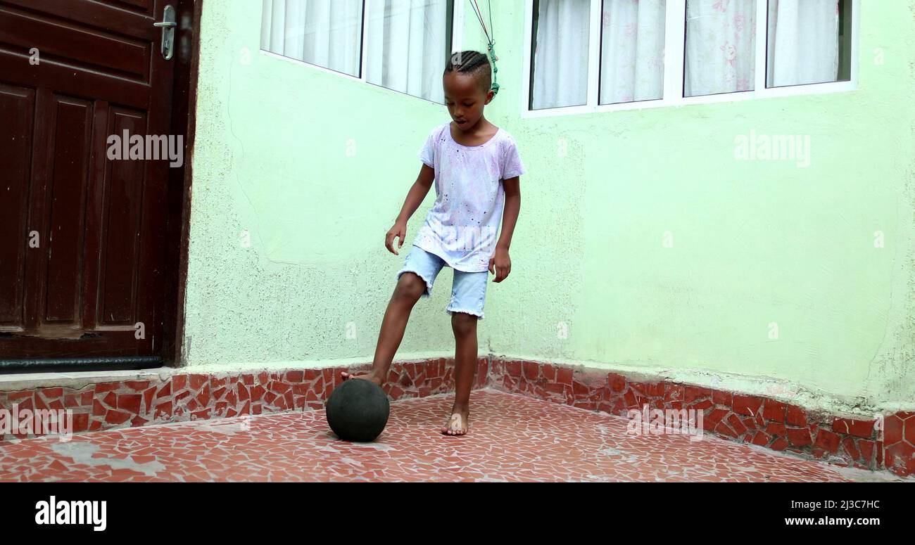 African child playing with ball, Black young boy kid plays sport by