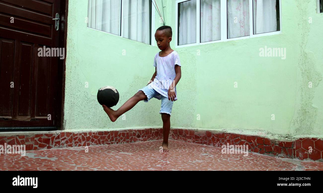 African child playing with ball, Black young boy kid plays sport by