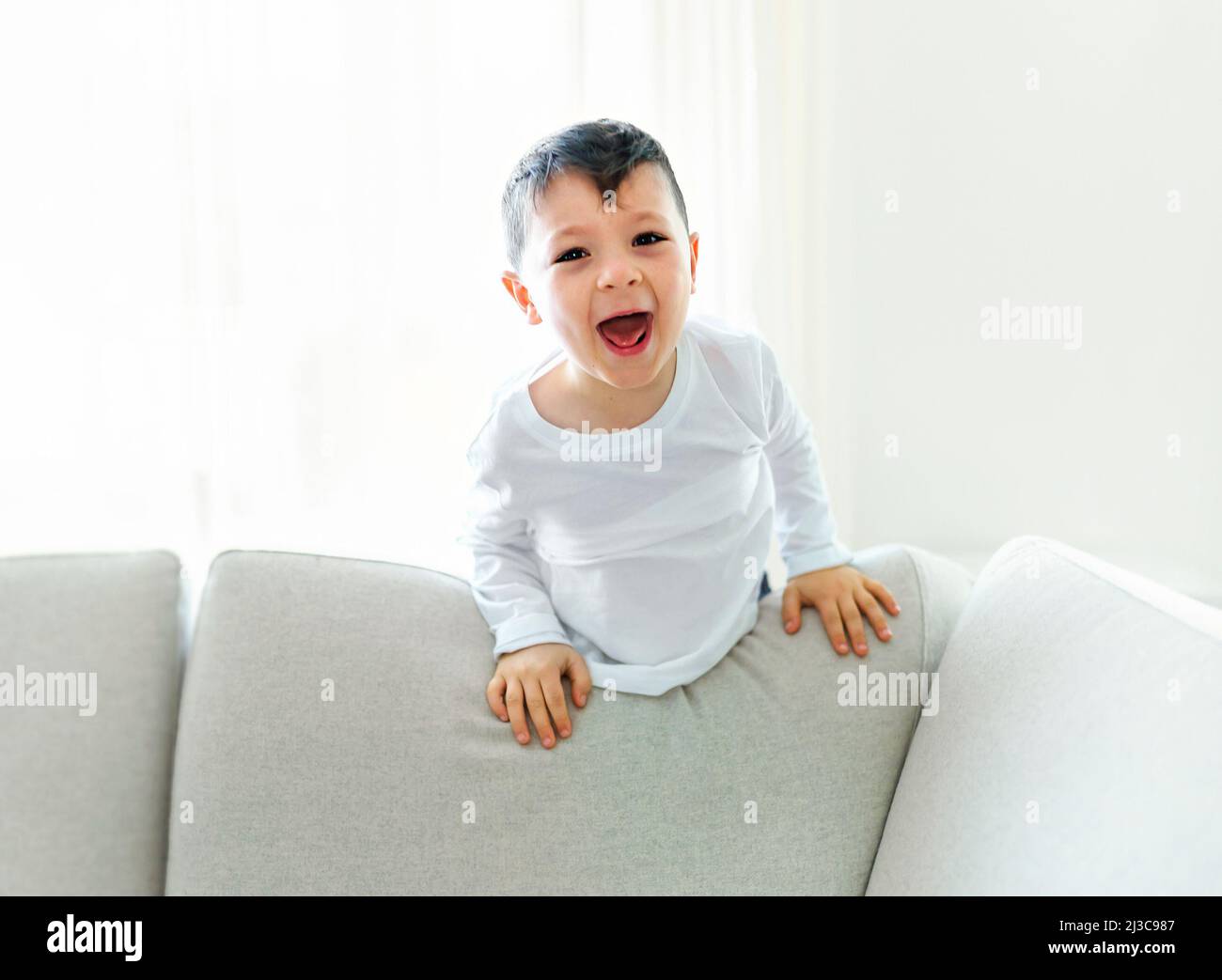 Little crazy boy on living room look like hyperactive Stock Photo