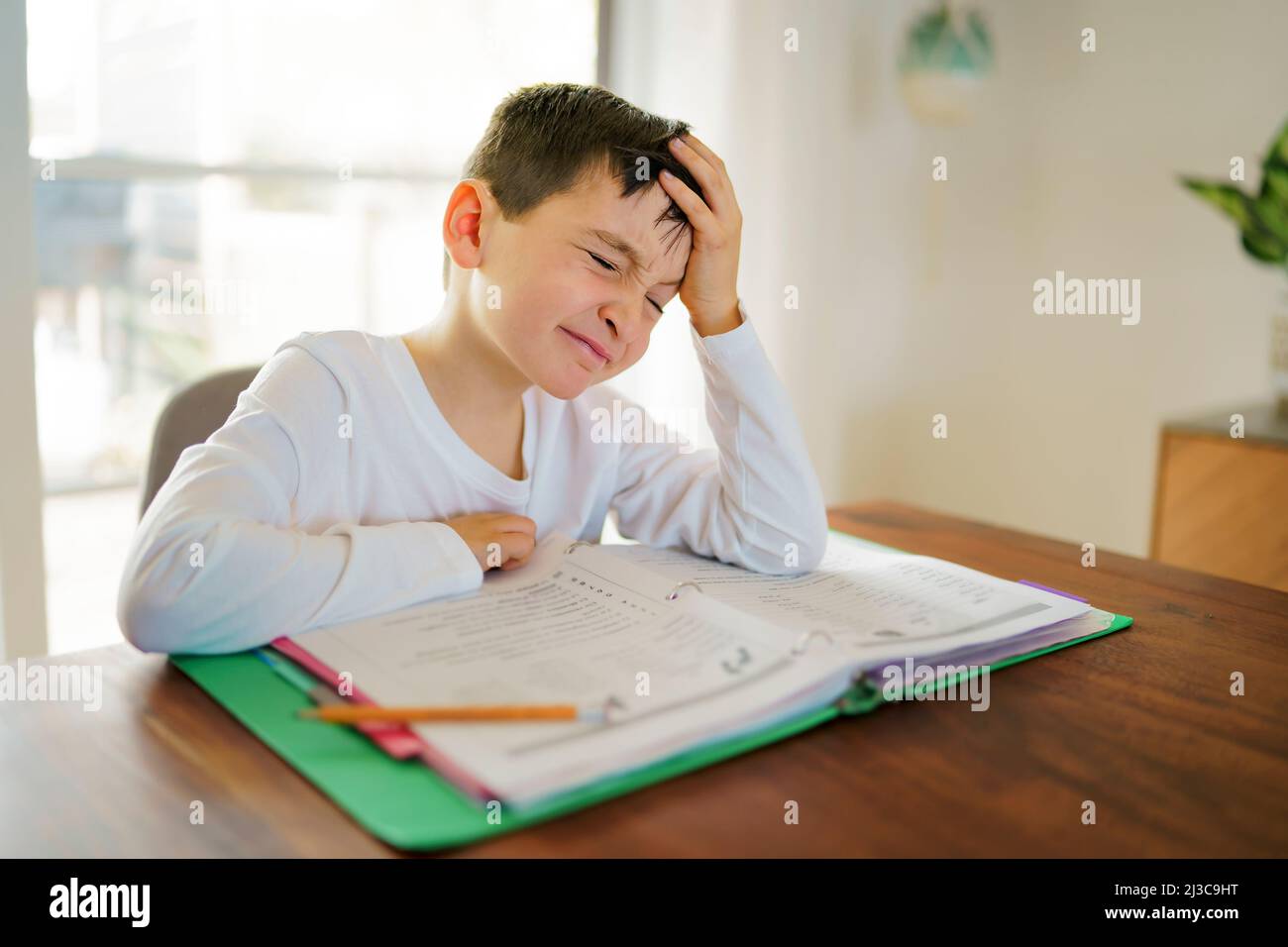 Thinking child bored and frustrated and fed up doing his homework Stock Photo