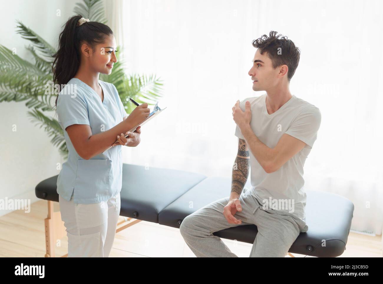 black rehabilitation woman physiotherapy at physio clinic with customer Stock Photo