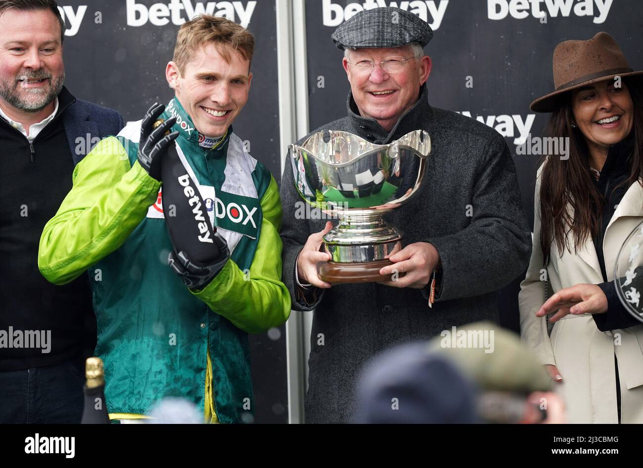 Sir Alex Ferguson celebrates with the Betway Bowl Chase trophy after his horse Clan Des Obeaux ridden by Harry Cobden (left) won the Betway Bowl Chase at Aintree Racecourse, Liverpool. Picture date: Thursday April 7, 2022. Stock Photo