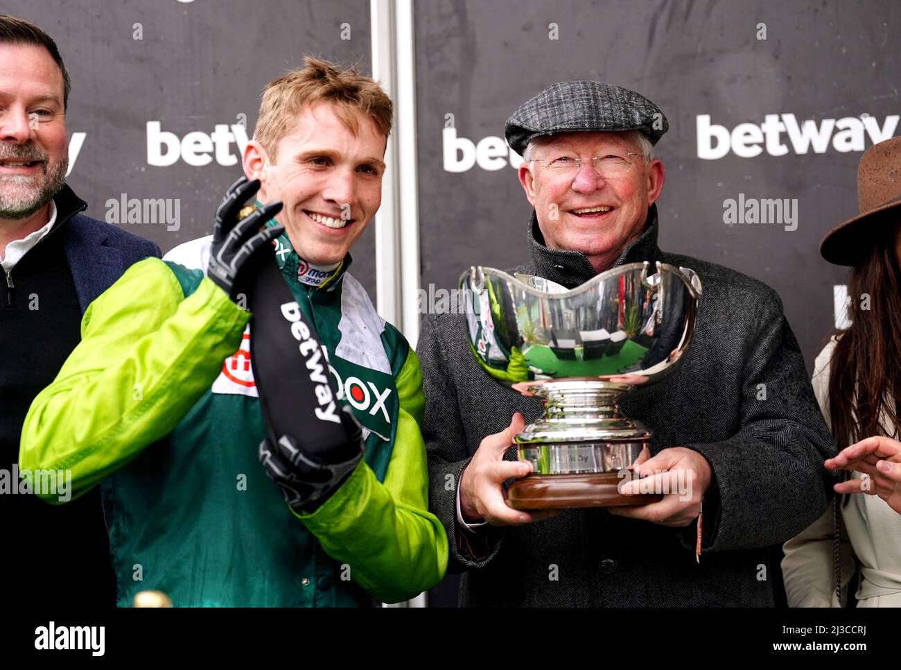 Co-owner Sir Alex Ferguson (right) celebrates with the Betway Bowl trophy alongside jockey Harry Cobden after Clan Des Obeaux wins the Betway Bowl Chase at Aintree Racecourse, Liverpool. Picture date: Thursday April 7, 2022. Stock Photo