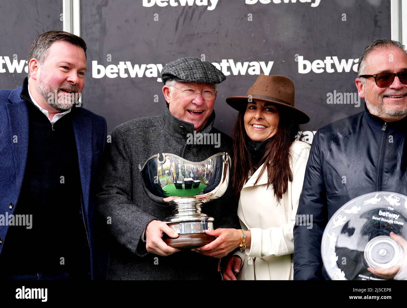 Co-owner Sir Alex Ferguson and the winning connections celebrate with the Betway Bowl trophy after Clan Des Obeaux wins the Betway Bowl Chase at Aintree Racecourse, Liverpool. Picture date: Thursday April 7, 2022. Stock Photo