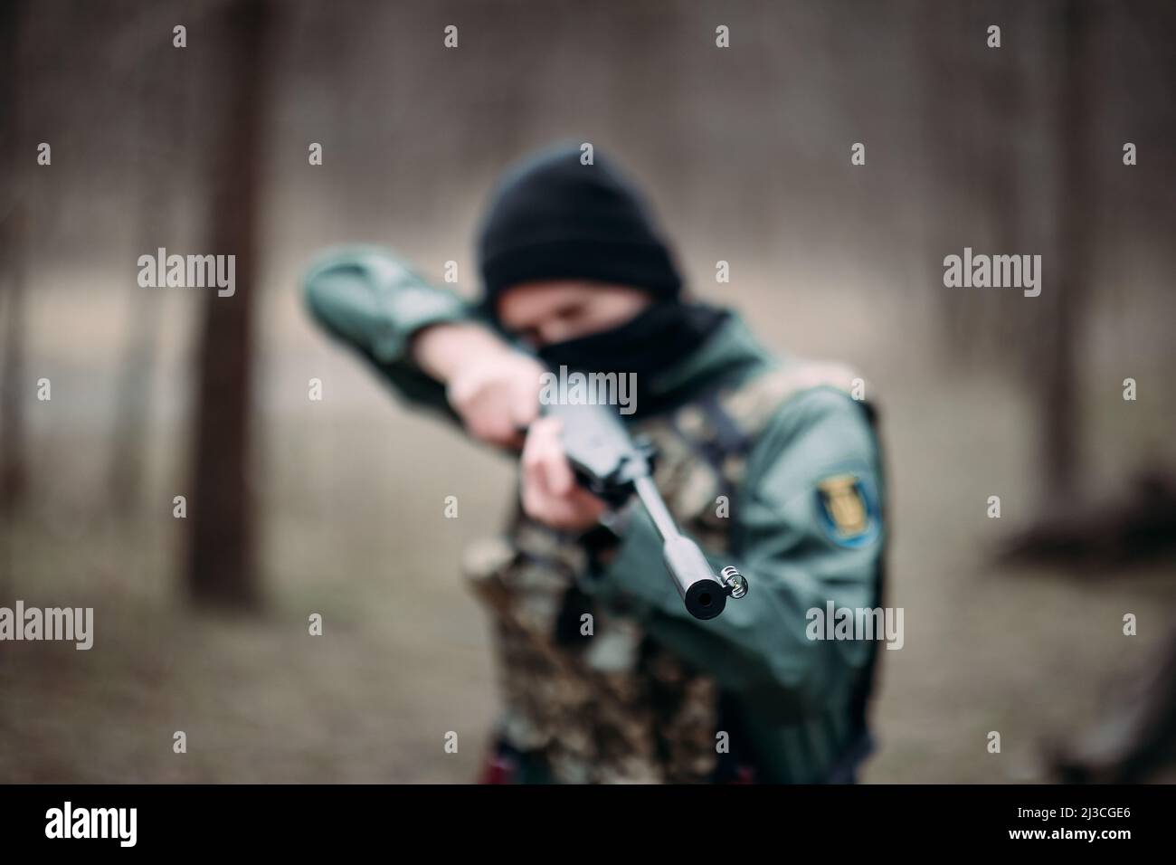 Young man practices and aims from pump gun weared in body armor and ...