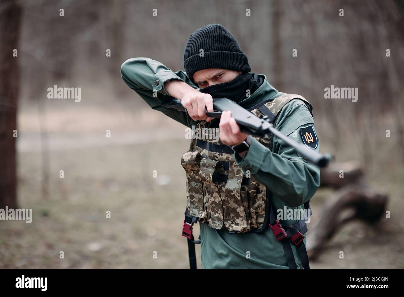 Young man practices and aims from pump gun weared in body armor and ...