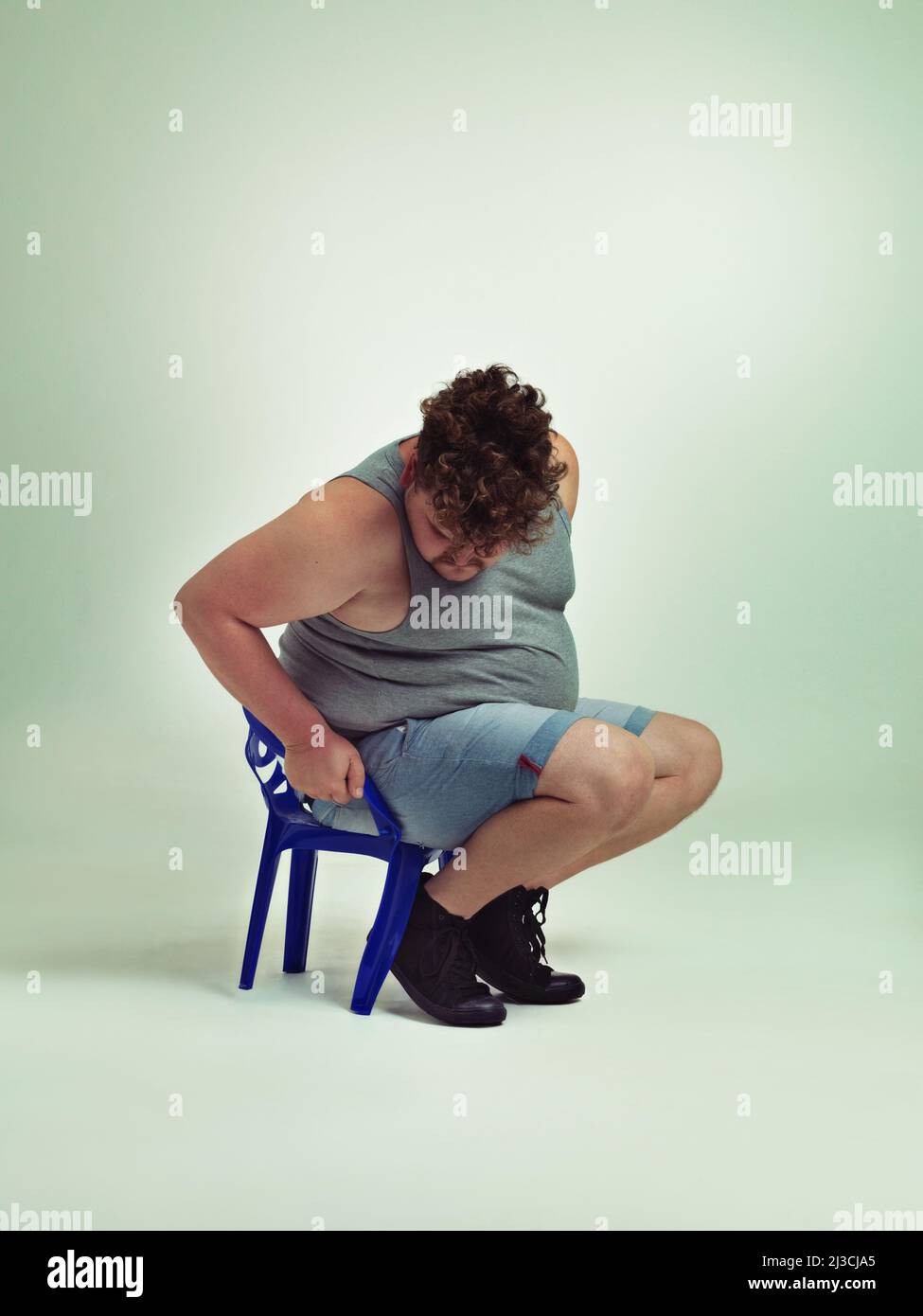 Did I get bigger or the chair smaller. Shot of an overweight man trying