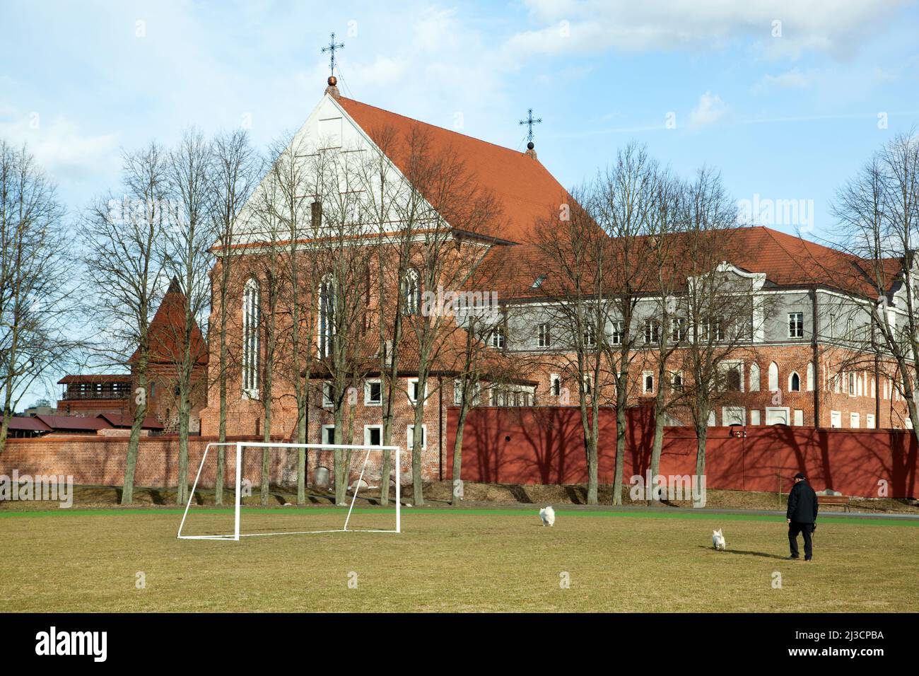 The early Spring view of a stadium in front of 15th century Roman Catholic Church of St. George the Martyr in Kaunas old town (Lithuania). Stock Photo