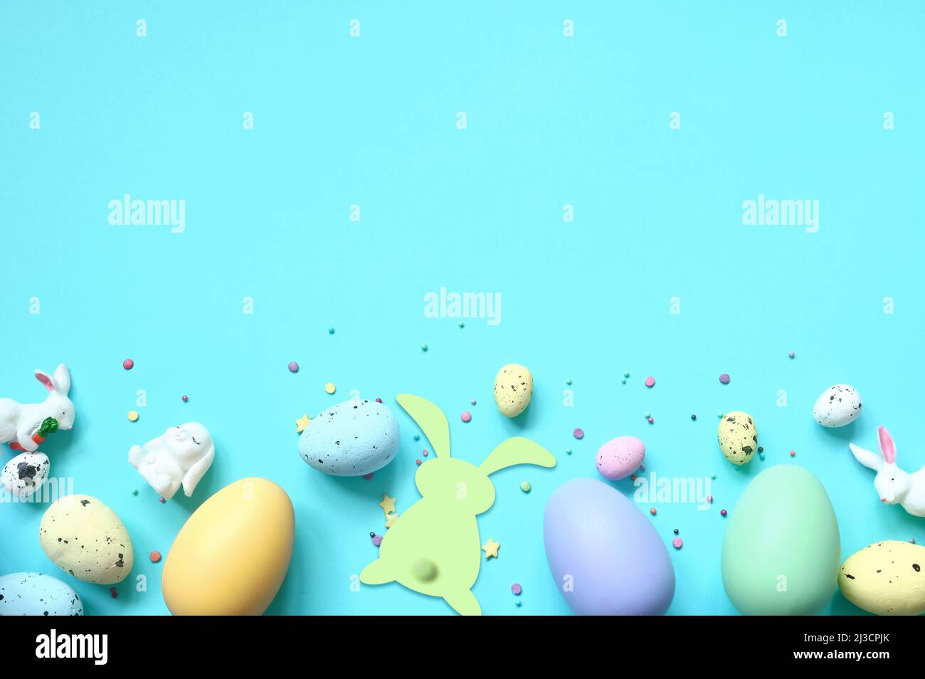 Easter composition. Easter eggs and easter bunny on pastel blue background. Minimal concept of Easter. Flat lay, top view, copy space Stock Photo