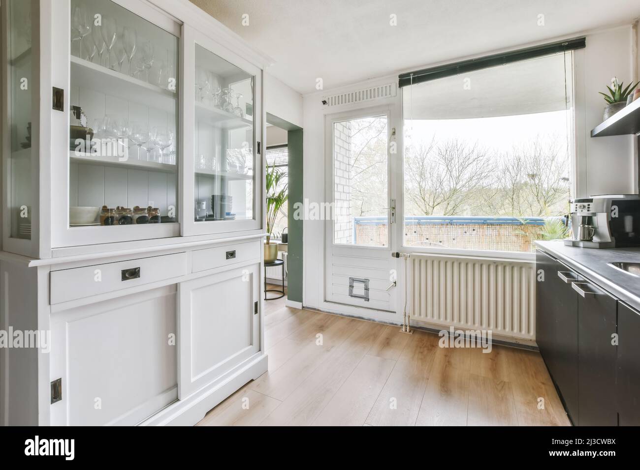 Interior of modern kitchen with white cupboard and black cabinets in flat designed in minimal ...