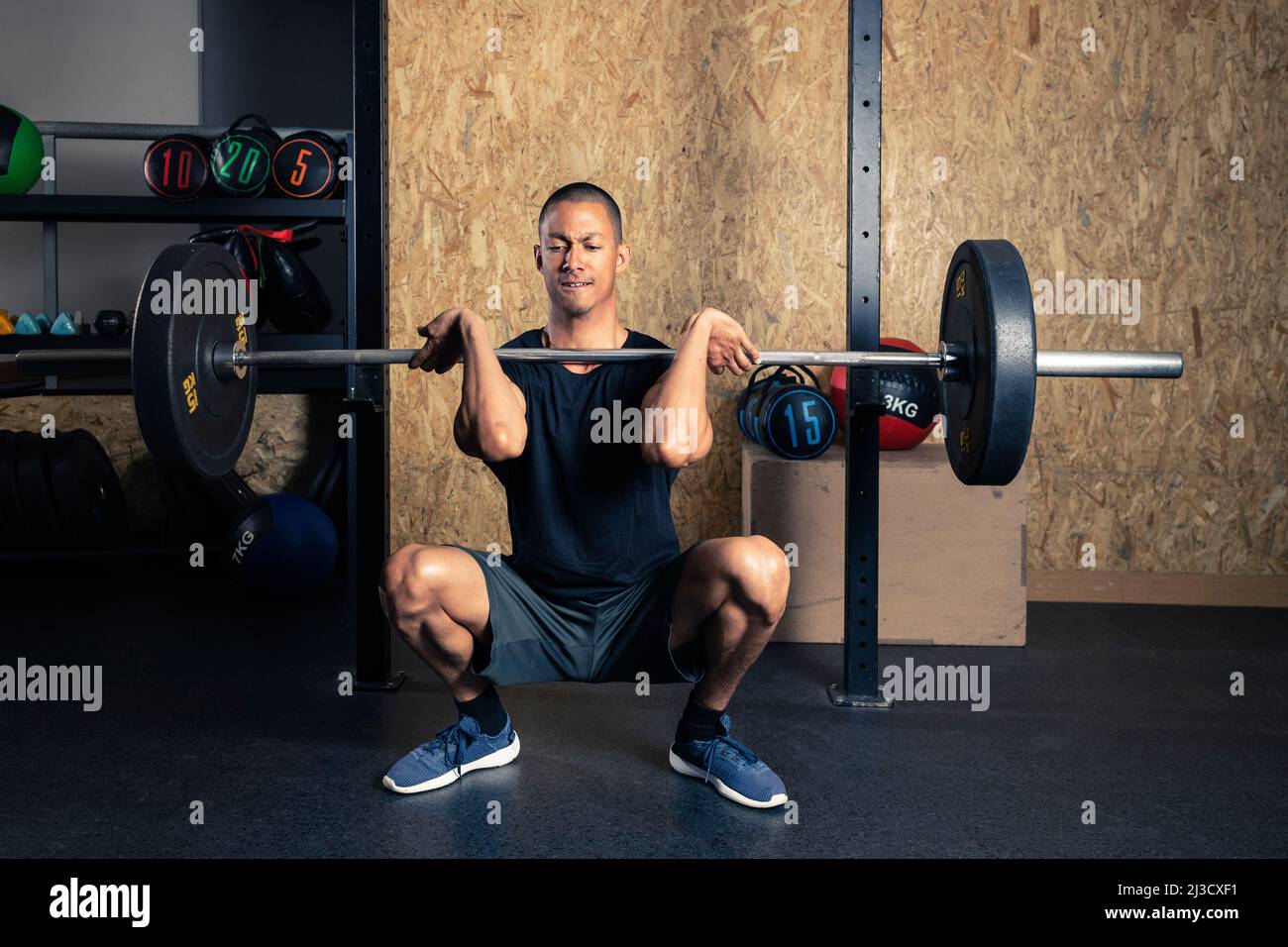 Full body of strong African American male powerlifter in activewear