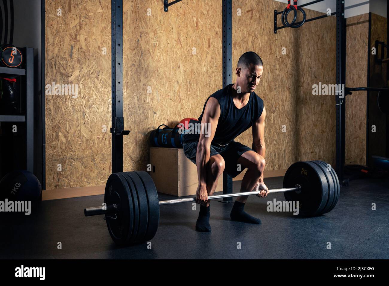 Full body of strong African American male powerlifter in activewear