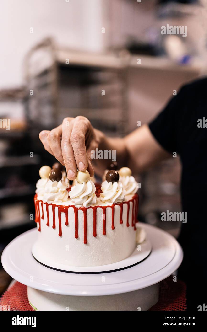 Crop anonymous chef pouring sauce on bread while making bruschetta on ...