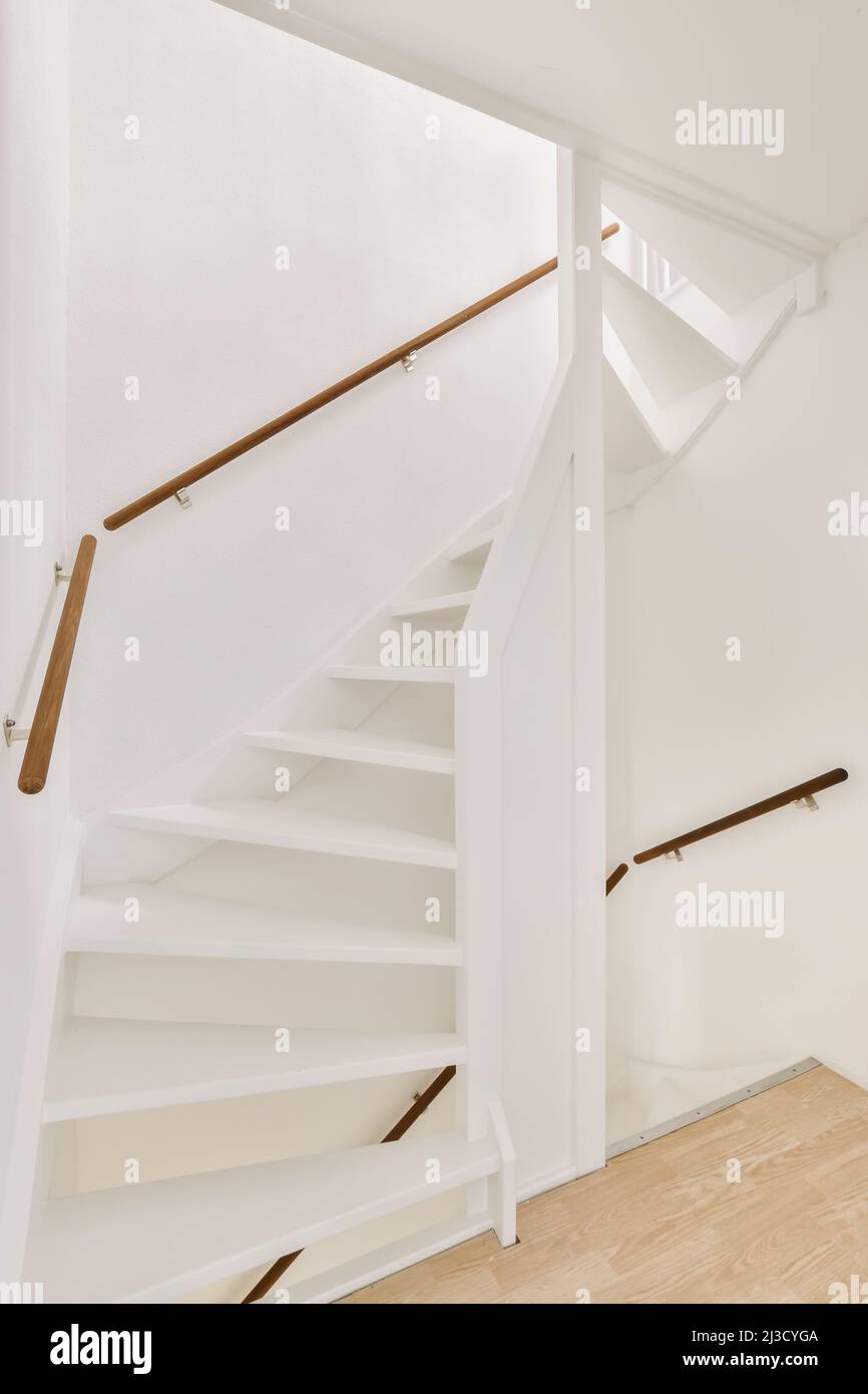 Passage Railing Interior of passage with white stair and wooden railings in minimal ...