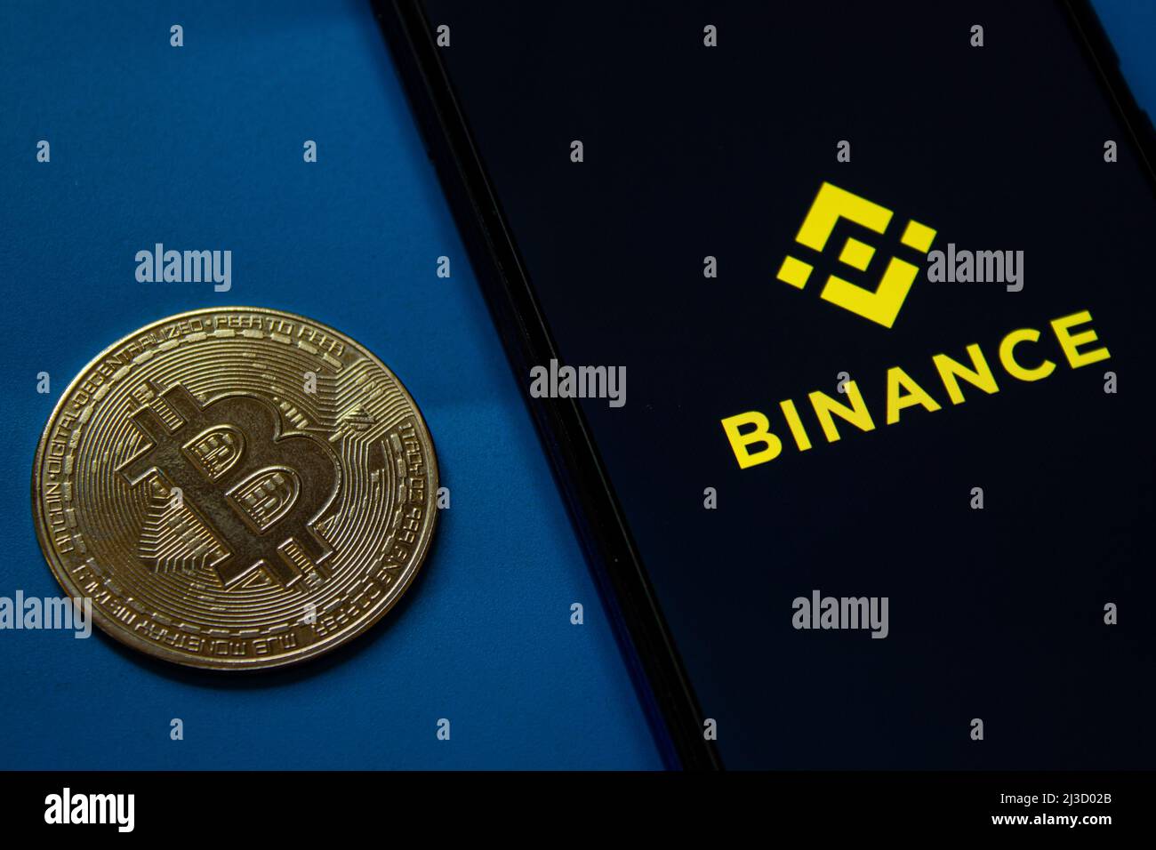 Binance mobile application logo on smartphone screen. Golden bitcoin coin. Afyonkarahisar, Turkey - April 6, 2022. Stock Photo