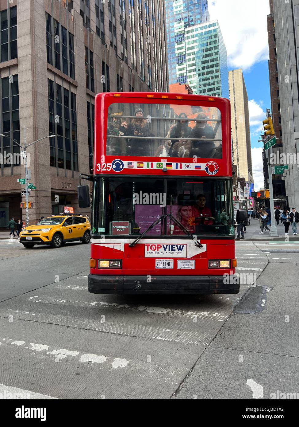 Tourist bus turns on to 6th Avenue from 46th Street also known as Little Brazil in midtown Manhattan, New york City. Stock Photo
