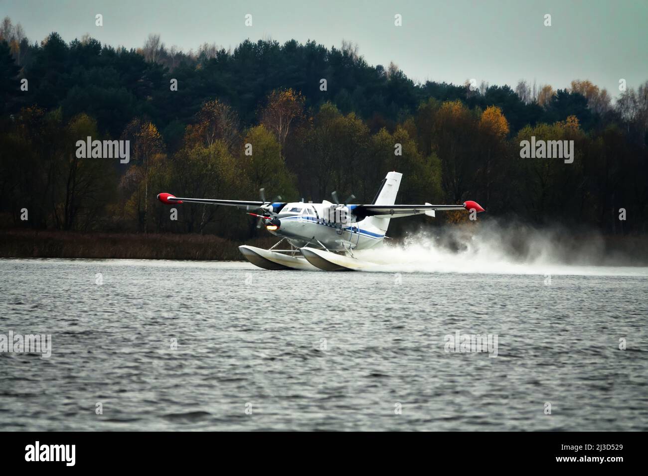 The Twinengine seaplane a seaplane rises from water, from the forest