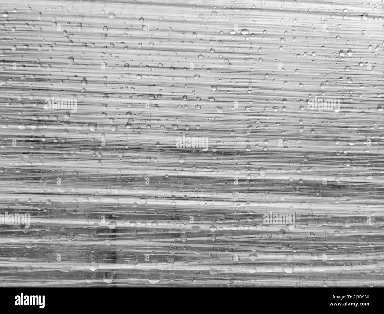 Raindrops on stretched plastic wrapping with wrinkles Stock Photo