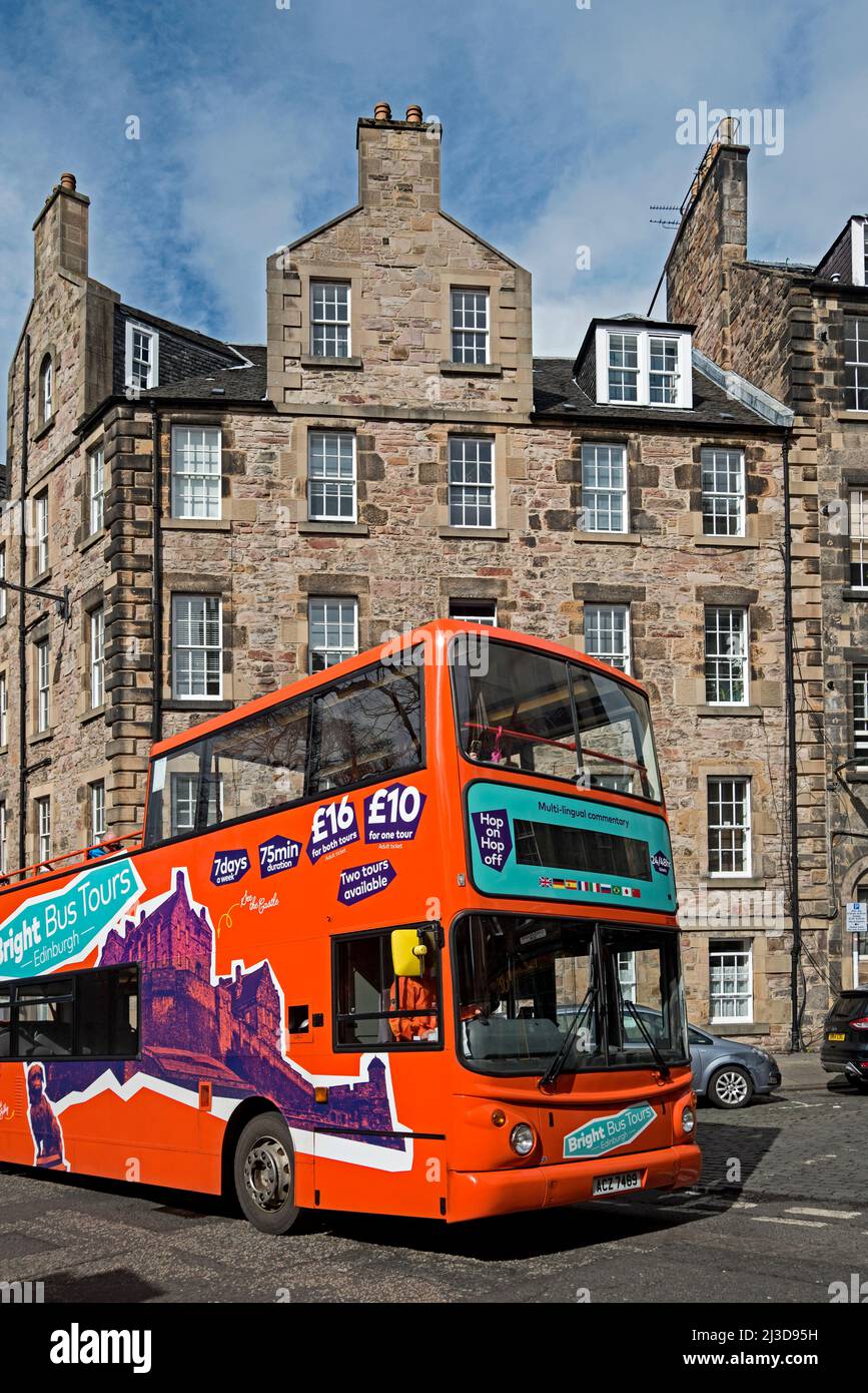 Open-topped tour bus driving up Candlemaker Row in Edinburgh's Old Town. Stock Photo