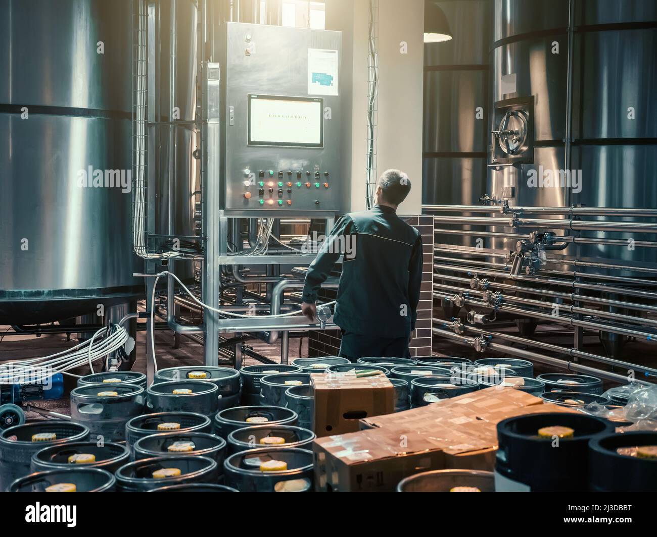 Brewer controlling automatic brewing process in modern microbrewery manufacturing craft beer. Stock Photo