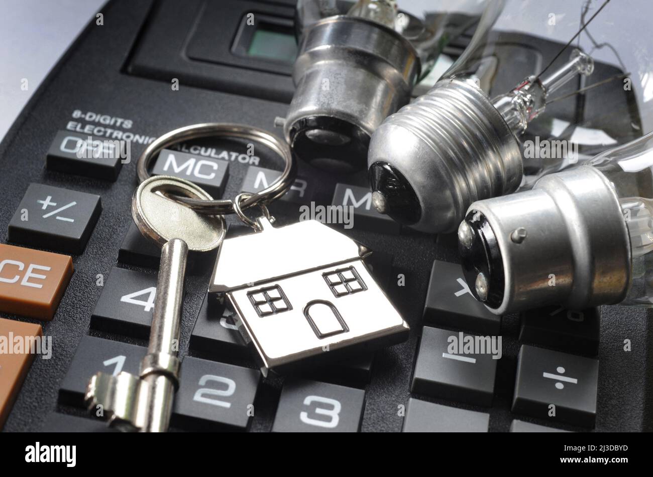 HOUSE KEY RING WITH DOMESTIC LIGHT BULBS ON CALCULATOR RE ENERGY BILLS ELECTRICITY RISING COSTS ETC UK Stock Photo