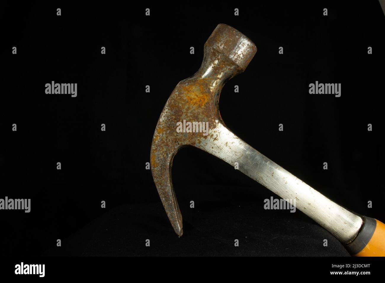 rusty hammer head and shaft with claw down isolated on a black background Stock Photo
