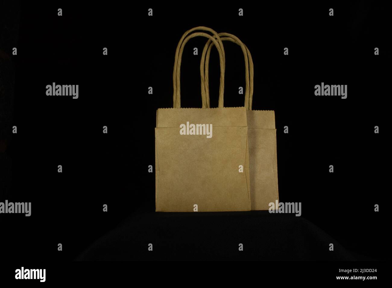 two overlapping mini recycled brown paper bags with paper handles