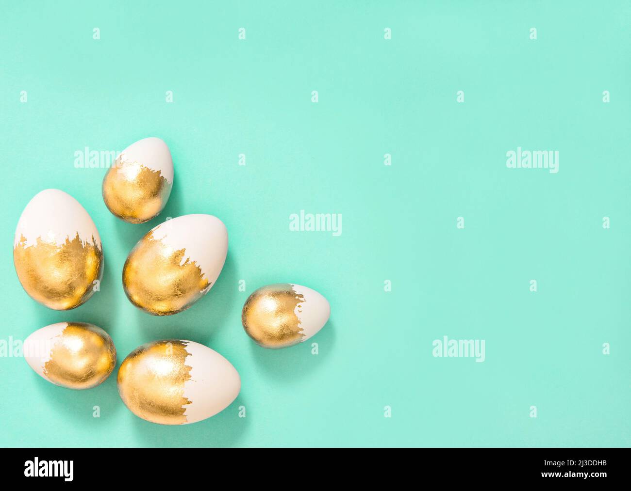 Easter decoration. Golden Easter eggs on turquoise background Stock Photo