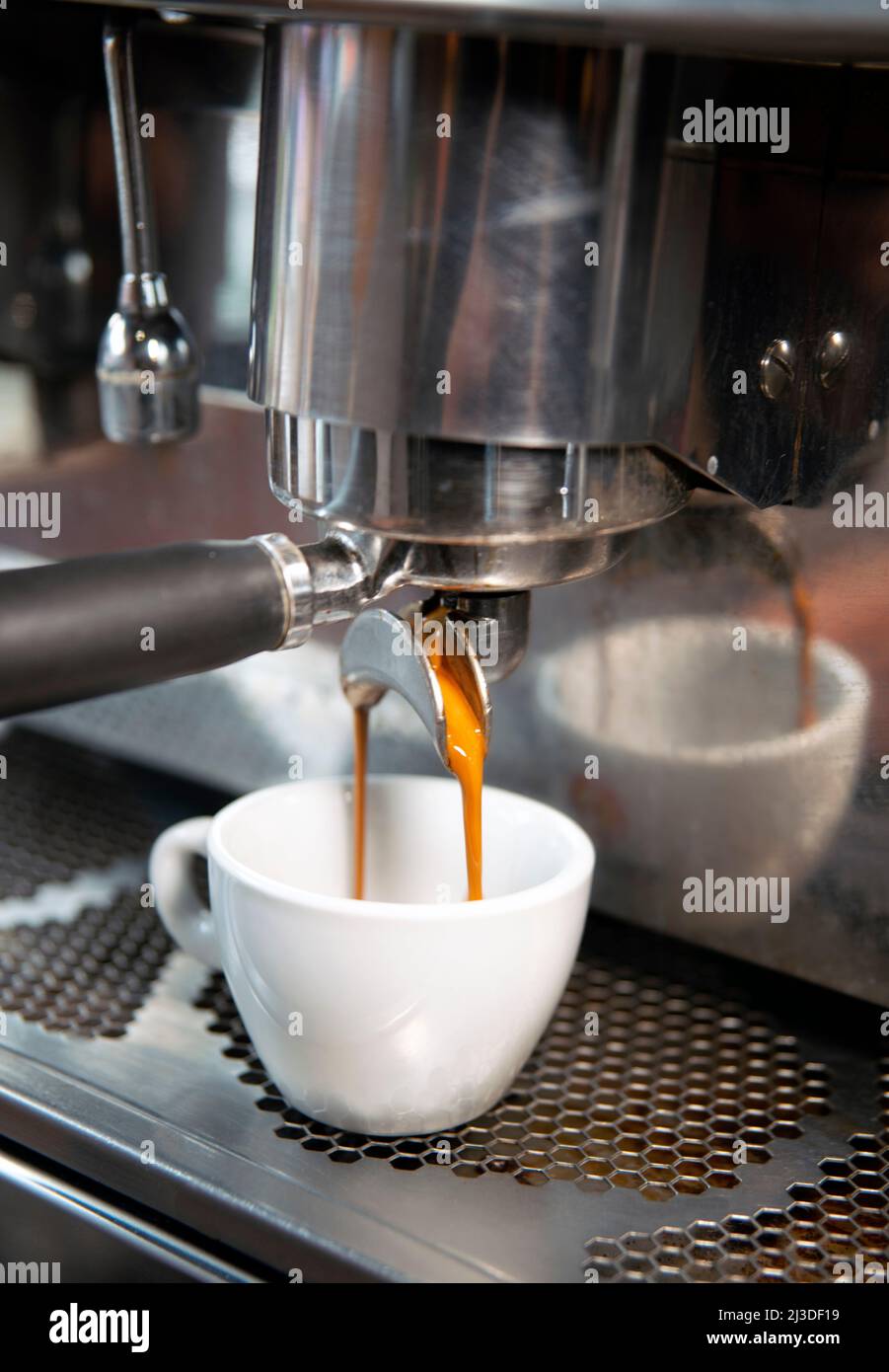 Creamy coffee pouring from a coffee machine up close Stock Photo