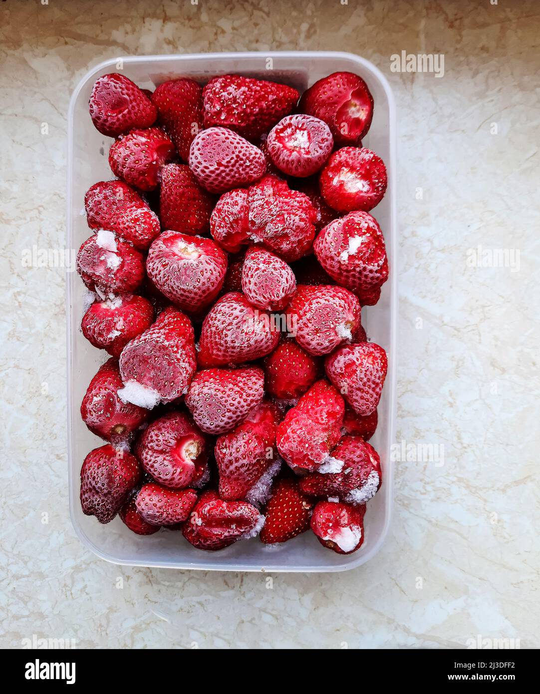 Frozen fruits in a container in the refrigerator, frozen berries