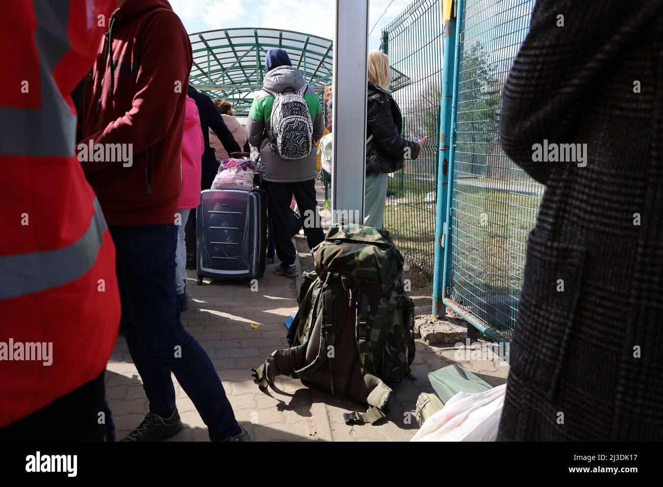 Medyka, Ukraine. 7th Apr, 2022. Thousands of Ukrainians fleeing Putin's terror stand in line for hours on the Ukrainian side at the Ukrainian/Polish border on April 6, 2022, waiting to enter the border town of Medyka. Here a man with a camouflage-back pack stands in foreground. (Credit Image: © Amy Katz/ZUMA Press Wire) Stock Photo